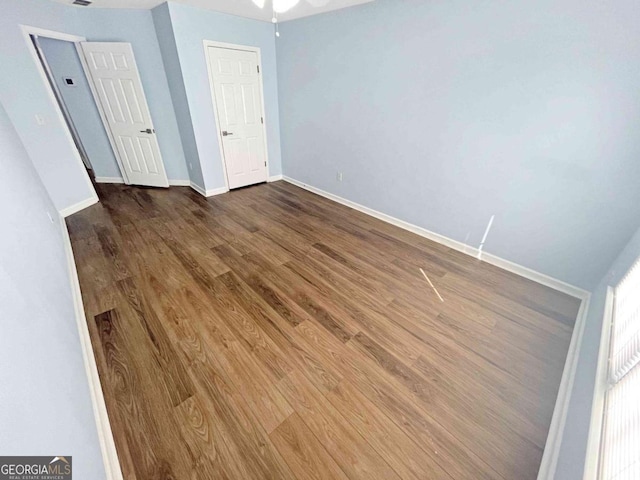 unfurnished bedroom with wood finished floors and baseboards