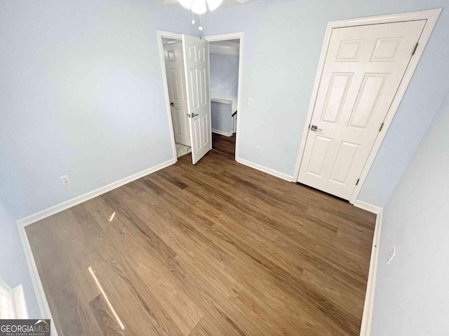unfurnished bedroom featuring baseboards and wood finished floors