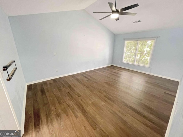 spare room featuring vaulted ceiling, wood finished floors, visible vents, and a ceiling fan