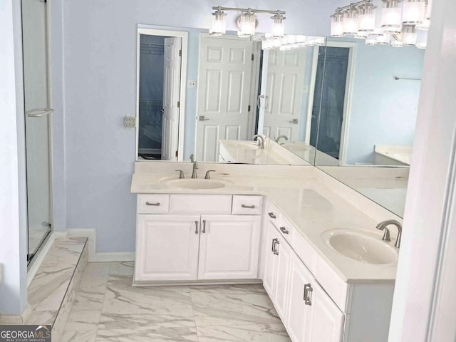 full bathroom featuring double vanity, marble finish floor, baseboards, and a sink