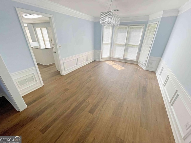 unfurnished dining area featuring a decorative wall, ornamental molding, and visible vents