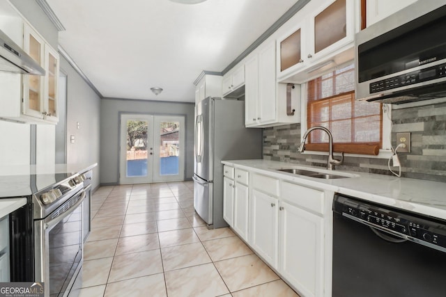 kitchen with stainless steel appliances, backsplash, wall chimney range hood, french doors, and a sink