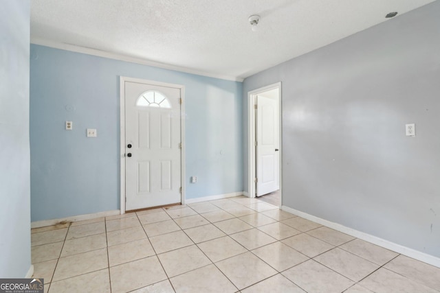 foyer featuring baseboards and a textured ceiling