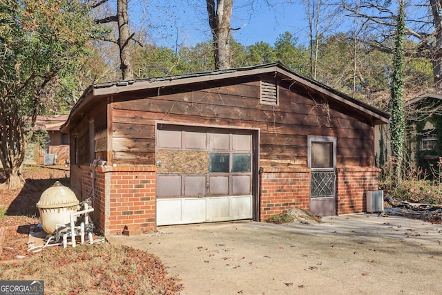 garage with driveway and central air condition unit
