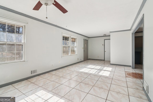 spare room with light tile patterned floors, ceiling fan, baseboards, ornamental molding, and visible vents