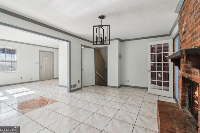 unfurnished living room featuring a chandelier, a brick fireplace, crown molding, and baseboards