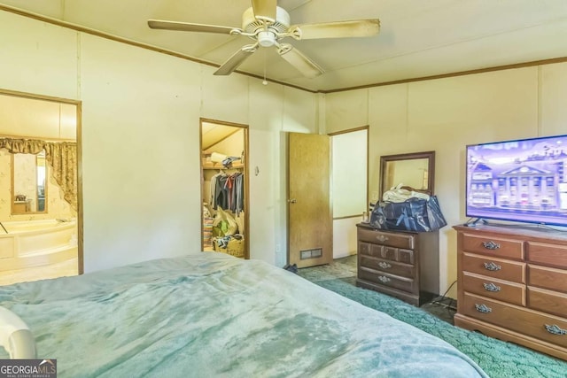 bedroom with carpet, a walk in closet, a closet, ceiling fan, and ensuite bathroom