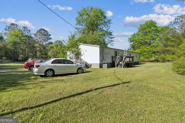 view of yard with a wooden deck and central AC