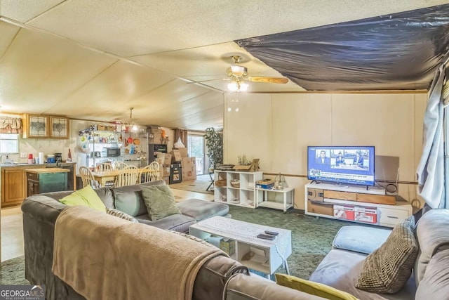 carpeted living area with vaulted ceiling and ceiling fan