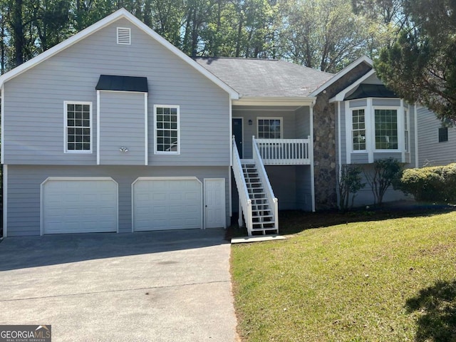 ranch-style house featuring stairway, concrete driveway, a porch, a front yard, and a garage