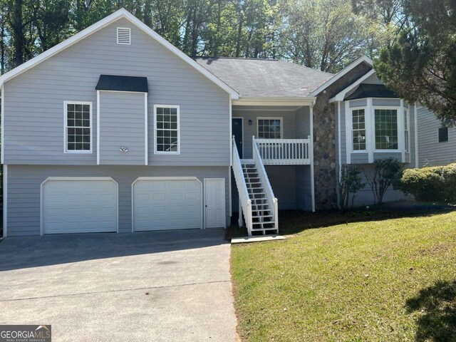 3861 Spring Meadow Dr, Acworth, GA 30101 - view of front of house with stairway, a front yard, an attached garage, driveway, and covered porch