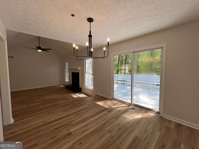 unfurnished dining area featuring visible vents, baseboards, wood finished floors, and a textured ceiling