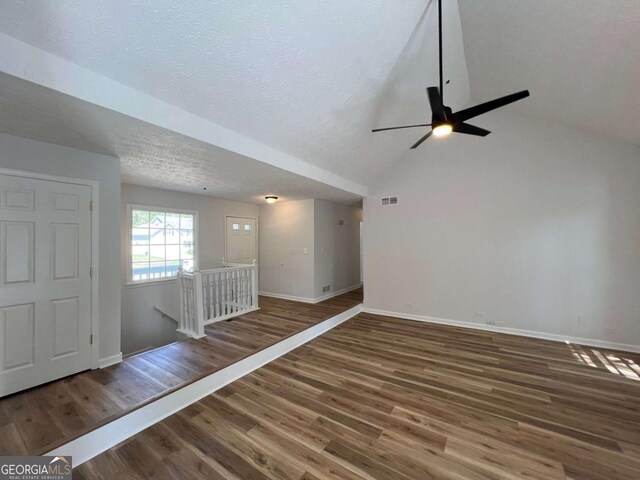 empty room featuring vaulted ceiling, a ceiling fan, wood finished floors, baseboards, and visible vents