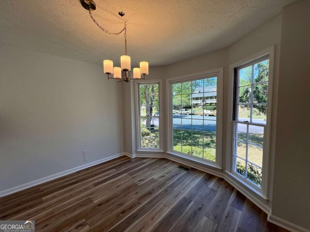 3861 Spring Meadow Dr, Acworth, GA 30101 - unfurnished dining area featuring a chandelier, a textured ceiling, and dark wood finished floors