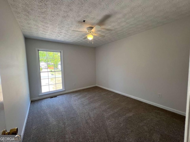 carpeted empty room featuring ceiling fan, baseboards, and a textured ceiling