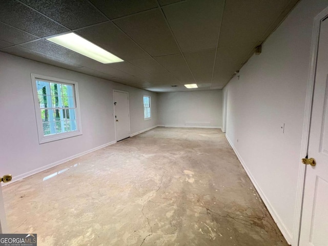 below grade area with baseboards and a drop ceiling