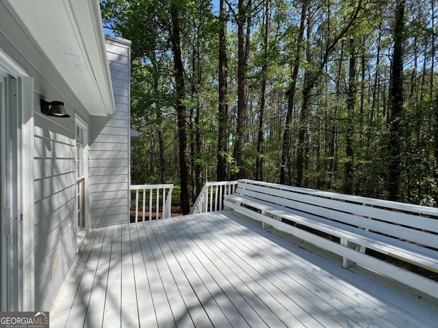 wooden deck featuring a forest view