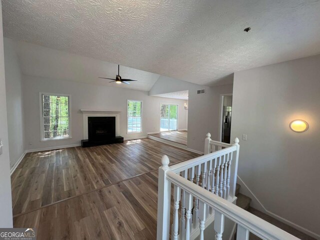 3861 Spring Meadow Dr, Acworth, GA 30101 - unfurnished living room with a textured ceiling, wood finished floors, plenty of natural light, ceiling fan, and lofted ceiling