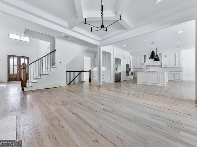 unfurnished living room with a chandelier, beamed ceiling, light wood finished floors, recessed lighting, and crown molding