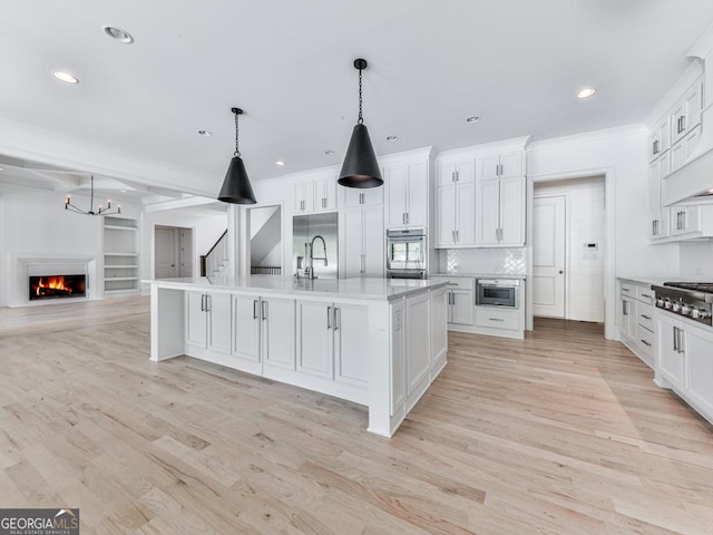 kitchen with stainless steel appliances, recessed lighting, light countertops, light wood-style flooring, and white cabinets