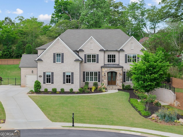 view of front of home with driveway, an attached garage, a shingled roof, and stone siding