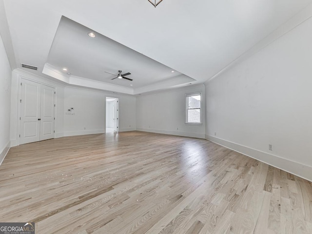 unfurnished living room with a tray ceiling, light wood-style flooring, baseboards, ceiling fan, and recessed lighting