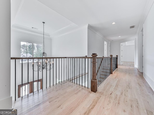 hall with a chandelier, wood finished floors, recessed lighting, baseboards, and ornamental molding