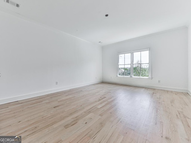 unfurnished room featuring light wood-type flooring, crown molding, and baseboards