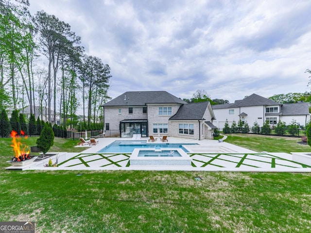 view of pool with a patio area, a pool with connected hot tub, and a fire pit