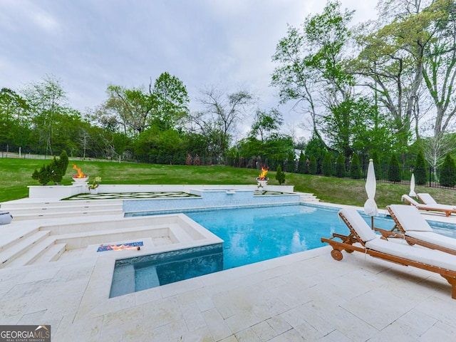 swimming pool with an in-ground hot tub, view of wooded area, and a patio