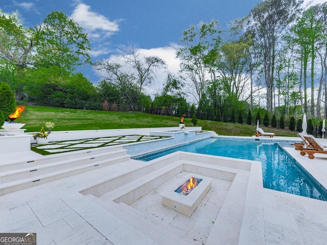 outdoor pool featuring a fire pit, a patio area, and view of wooded area