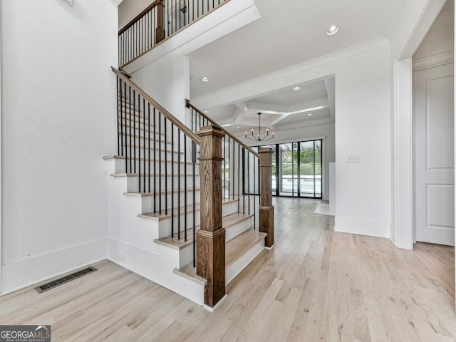 stairs featuring coffered ceiling, a chandelier, wood finished floors, recessed lighting, and beam ceiling