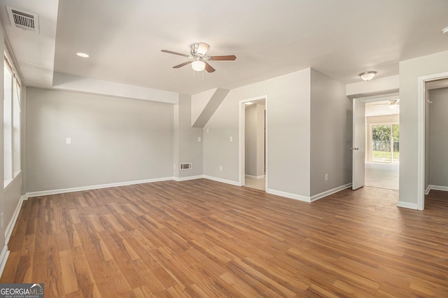unfurnished living room with wood finished floors, visible vents, and ceiling fan