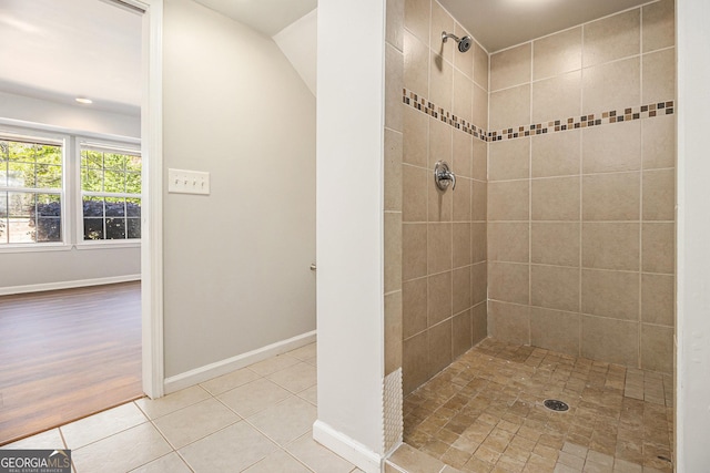 full bathroom with baseboards, tile patterned floors, and tiled shower
