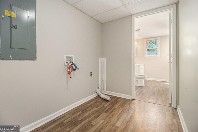 laundry area featuring electric panel, baseboards, hookup for a washing machine, wood finished floors, and electric dryer hookup