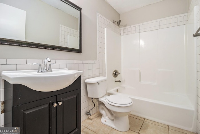 bathroom with vanity, tub / shower combination, tile walls, toilet, and tile patterned flooring