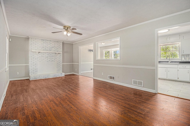 unfurnished living room featuring visible vents, ornamental molding, and ceiling fan