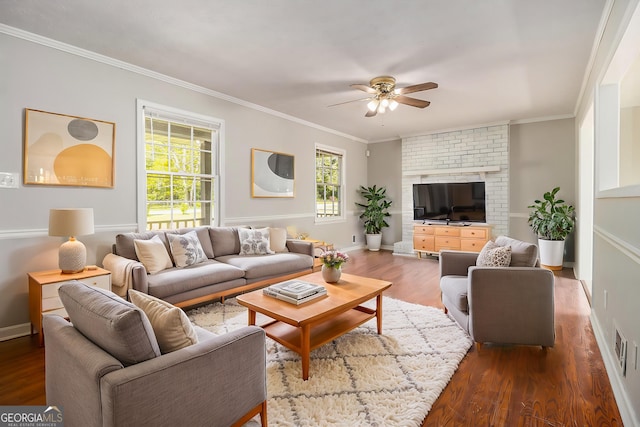 living area with wood finished floors, a ceiling fan, baseboards, and ornamental molding