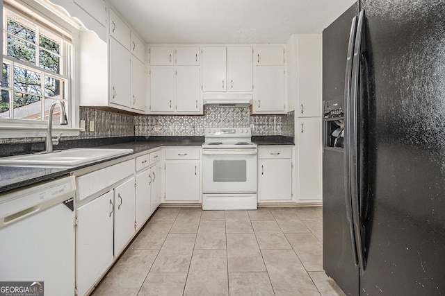 kitchen with dark countertops, tasteful backsplash, a sink, white appliances, and under cabinet range hood