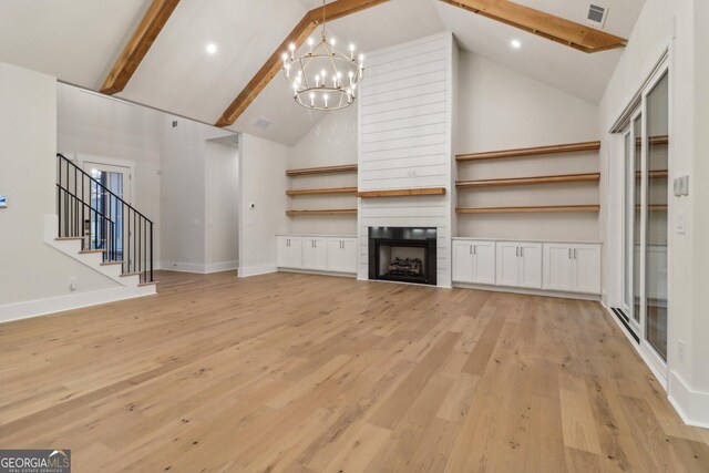 117 Wildwood Dr, Eatonton, GA 31024 - unfurnished living room with a chandelier, high vaulted ceiling, stairs, and beamed ceiling