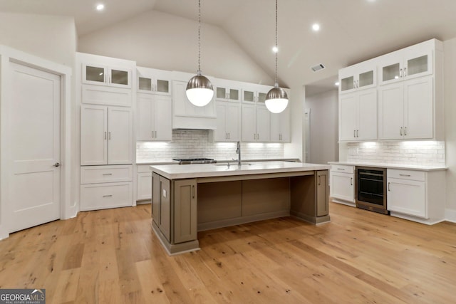 117 Wildwood Dr, Eatonton, GA 31024 - kitchen with wine cooler, backsplash, visible vents, a sink, and a kitchen island with sink