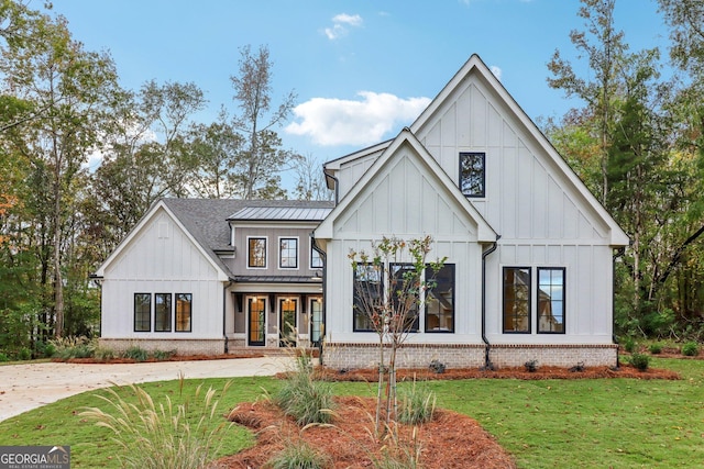 117 Wildwood Dr, Eatonton, GA 31024 - view of front of home with board and batten siding, a front yard, metal roof, brick siding, and a standing seam roof