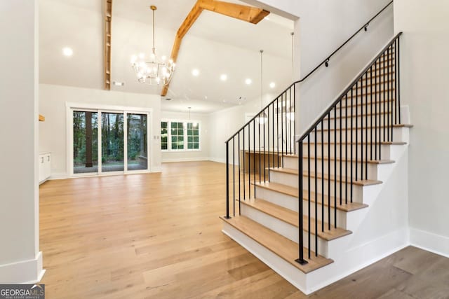 117 Wildwood Dr, Eatonton, GA 31024 - stairs featuring wood finished floors, baseboards, and a chandelier