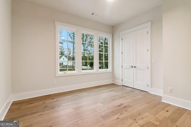 117 Wildwood Dr, Eatonton, GA 31024 - unfurnished bedroom with a closet, light wood-style flooring, visible vents, and baseboards