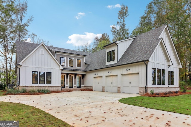 117 Wildwood Dr, Eatonton, GA 31024 - rear view of property featuring roof with shingles, concrete driveway, brick siding, a garage, and board and batten siding
