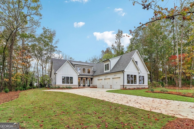 117 Wildwood Dr, Eatonton, GA 31024 - back of property featuring board and batten siding, a lawn, a garage, and driveway