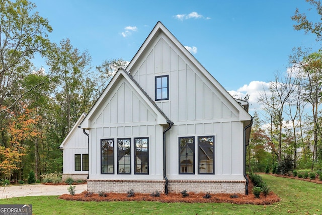 117 Wildwood Dr, Eatonton, GA 31024 - rear view of house featuring board and batten siding, brick siding, and a yard