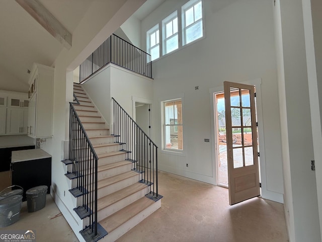 117 Wildwood Dr, Eatonton, GA 31024 - foyer with baseboards, concrete flooring, a high ceiling, and stairway
