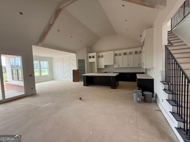 117 Wildwood Dr, Eatonton, GA 31024 - kitchen featuring high vaulted ceiling, a center island, concrete flooring, glass insert cabinets, and white cabinets