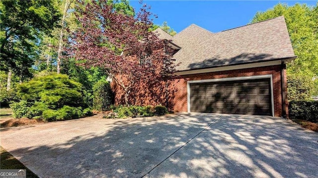 204 Overland Trl, Mcdonough, GA 30252 - view of side of property with an attached garage, driveway, brick siding, and roof with shingles